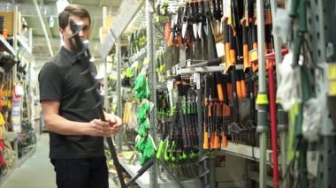 Erkek müşteri Bahçe mağaza seçerek el ile auger delik için matkap