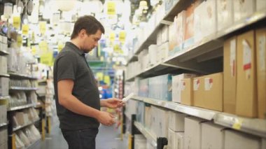 Alışveriş merkezinde erkek müşteri. Eller enerji verimli ampuller elinde