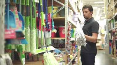 Alışveriş merkezinde bir paspas seçme erkek bir aile reisi