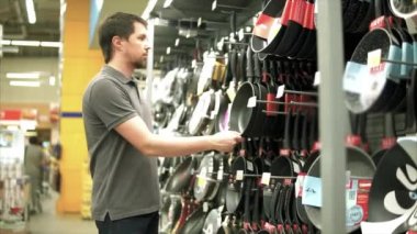 Adam kap seçme dükkanda. O eller mutfak tencereye alarak