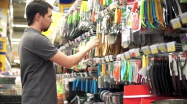 Erkek müşteri onun mutfak için tahta spatula satın alma. Başlangıç rafı götürdüğünü
