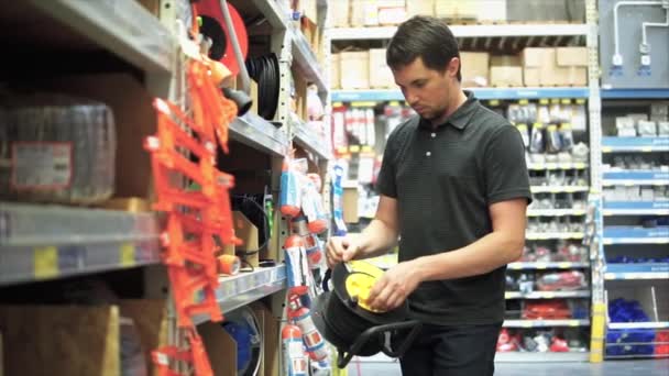 Cliente masculino escolhendo um cabo de extensão de fio elétrico com um cabo longo . — Vídeo de Stock