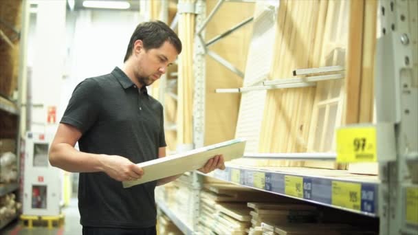 Клиент в хозяйственном магазине выбирает деревянные поделки — стоковое видео