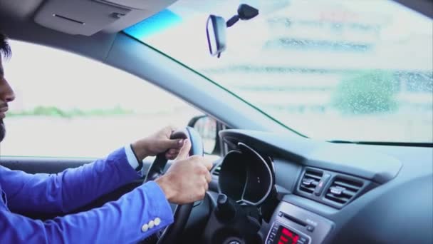Islamitische man in blauwe pak besturen van de auto. Knappe ernstige zakenman — Stockvideo