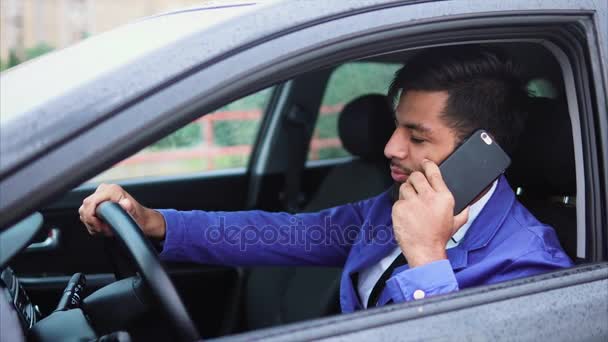 Joven hombre de negocios musulmán moderno hablando en el teléfono inteligente en el coche . — Vídeos de Stock