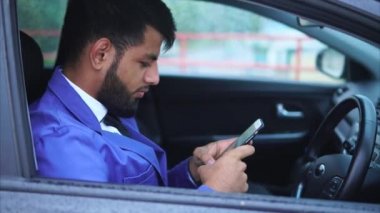 Arabada oturan ve Smartphone'da yazarak Müslüman işadamı