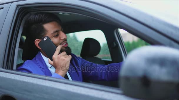 Hombre árabe moderno en ropa formal sentado en el coche de la derecha — Vídeo de stock