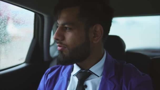 年轻的穆斯林商人，骑在车上的乘客座位上. — 图库视频影像