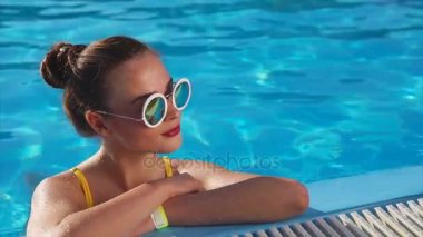Genç kadın güneş gözlüğü havuz, güzel havalarda tadını güneşli bir gün
