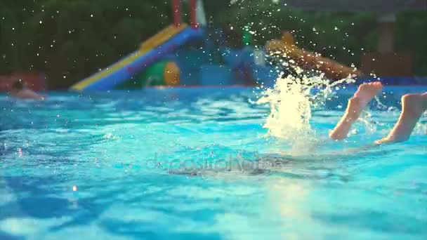 Carino e giovane ragazza si tuffa in piscina per rinfrescarsi in una giornata calda — Video Stock