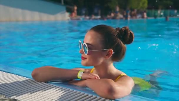 Mulher elegante descansa na piscina e gosta de nadar na água, descanso de verão — Vídeo de Stock