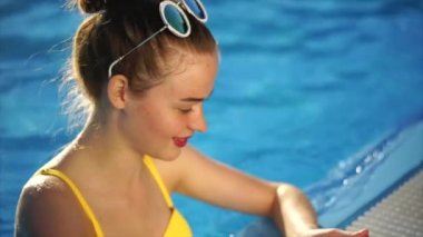 Genç kadın bir mayo sosyal ağlar için bir cep telefonu fotoğrafları inceliyor