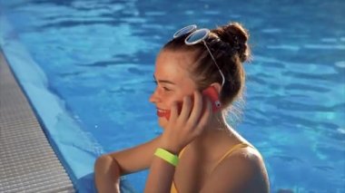 Genç bir kadın su telefonda konuşuyor, o bir arkadaş arıyor