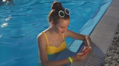 Bir cep telefonu üzerinde arkadaşlarınızla güneşli bir günde karşılık gelen çekici kadın