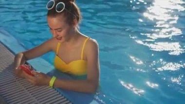 Bir cep telefonu üzerinde arkadaşlarınızla güneşli bir günde karşılık gelen çekici kadın