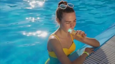 İyi bir ruh hali ile güzel ve genç bir kadın bir dondurma havuzuna sahiptir