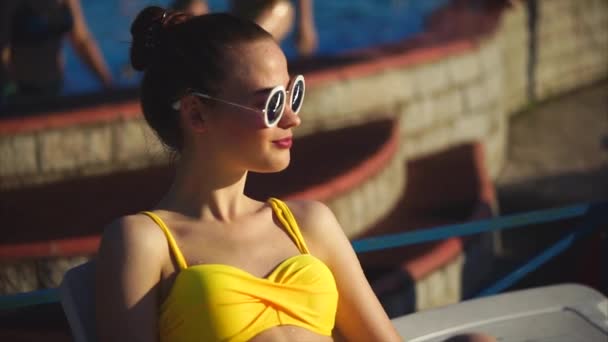 Atractiva mujer en traje de baño amarillo y gafas de sol disfrutando de la recreación — Vídeos de Stock