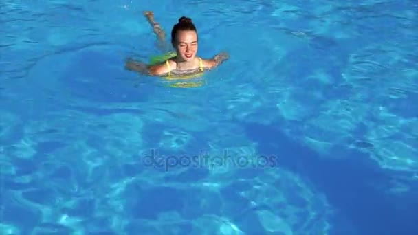 Una chica feliz y adulta nada en la piscina a un lado, la temporada de verano — Vídeos de Stock