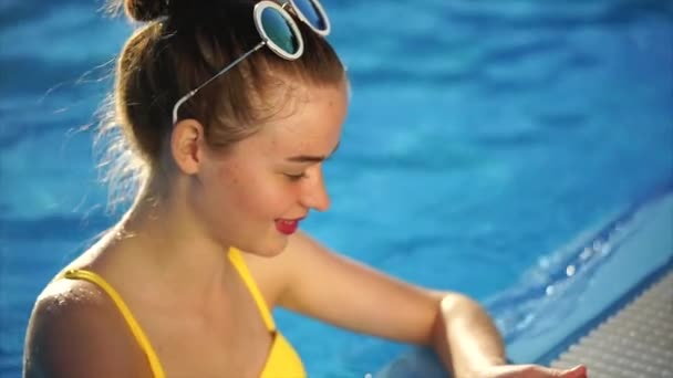 Giovane donna in costume da bagno esamina le foto su un telefono cellulare per i social network — Video Stock