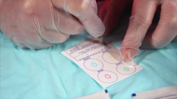 Arzt füllt Blankoausweis für Blutgruppentest aus. typisches Verfahren — Stockvideo