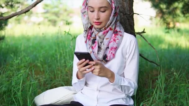 Giovane e moderna donna musulmana che parla comunica tramite telefono cellulare con gli amici — Video Stock