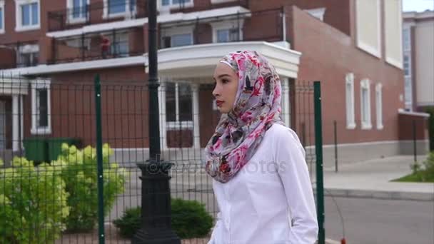 年轻的阿拉伯妇女走在街上，戴盖头在一个现代化的城市 — 图库视频影像