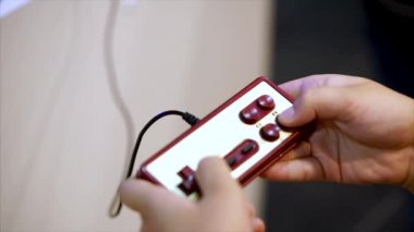 Retro klasik gamepad ve player'ın elleri. Düğmelere basarak ve oynayan oyuncu