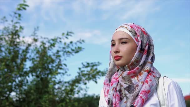 Молодая мусульманка в ярком хиджабе, портрет на открытом воздухе — стоковое видео