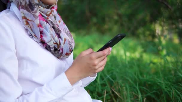 Muslim girl with cell in the park — Stock Video