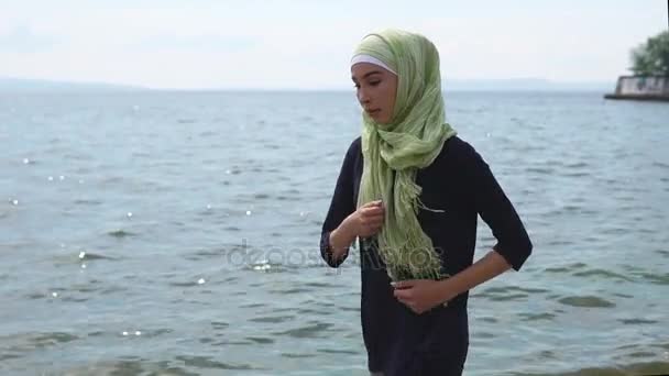 Muslimisches Mädchen joggt am Meer entlang — Stockvideo