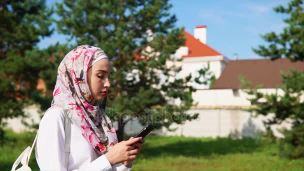 Muslimská dívka pomocí buňky na cestách — Stock video