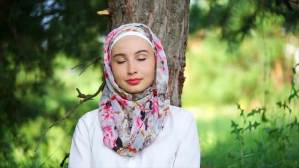 Porträt eines muslimischen Mädchens gegen die grüne Natur — Stockvideo