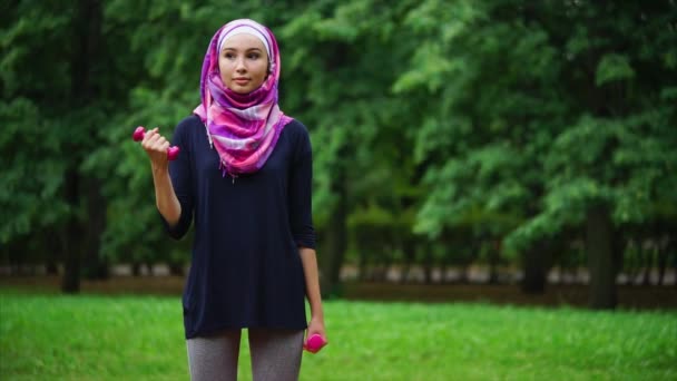 Muslim gadis berolahraga dengan dumbbells luar ruangan — Stok Video