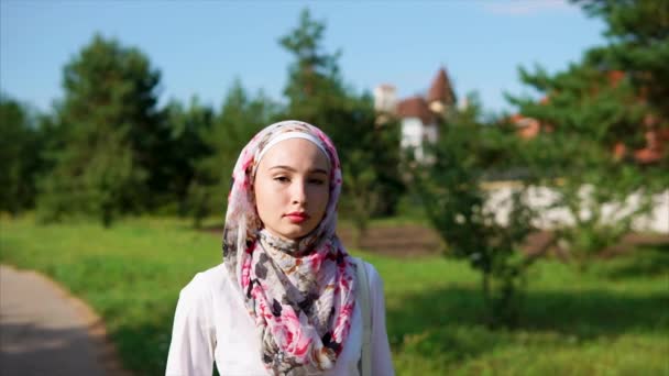 Mujer árabe joven caminando en el parque con un hijab en una ciudad moderna — Vídeos de Stock
