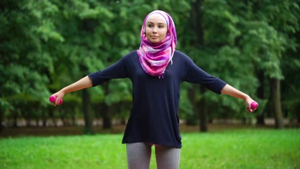 Muslim gadis berolahraga dengan dumbbells luar ruangan — Stok Video