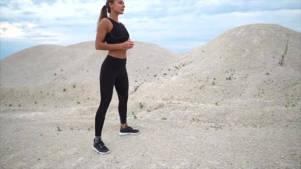 Girl doing squats exercise during workout outside the city — Stock Video