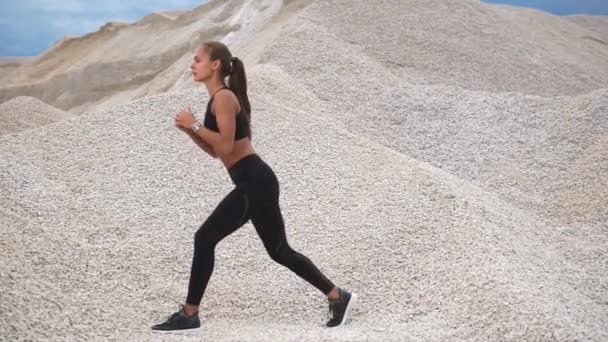 Young athlete does exercises on the muscles of the buttocks in nature she squats — Stock Video
