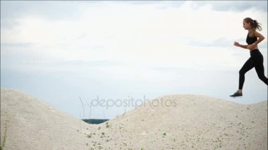 Genç kadın aktif spor yarışmaları kumlu park boyunca çalışır için eğitiyor.