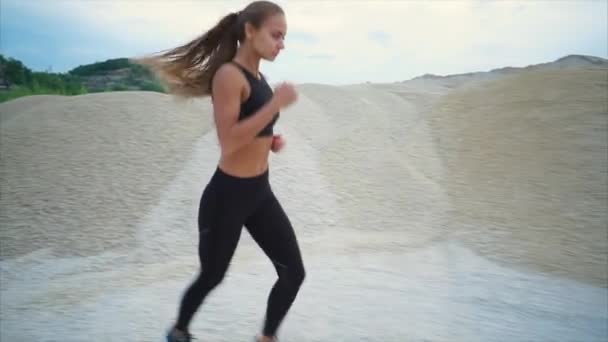 Lány jogging mentén a kavics hegyekre nyitott gödör — Stock videók