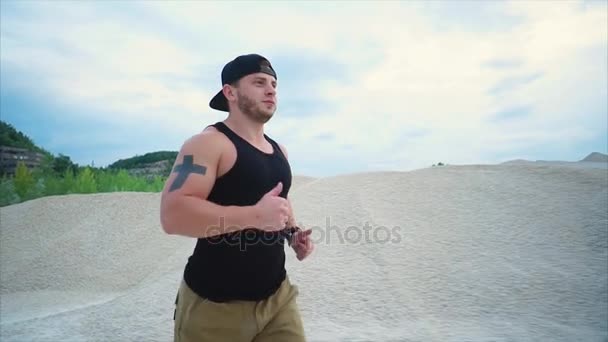 Un homme qui fait du sport à la carrière. Il courait parmi les collines de gravier — Video