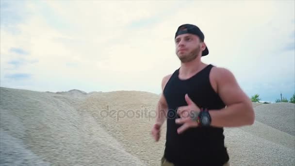 Un homme qui fait du sport à la carrière. Il courait parmi les collines de gravier — Video