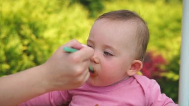 Cute, komik çocuk benim anneler kaşık sebze püresi açık havada yiyor.
