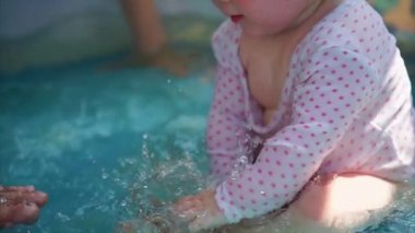 Küçük bir çocuk çocuk havuzunda oynuyor, su su bendi kapağı
