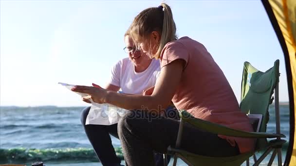 Vento forte perto do mar impede que os cônjuges mantenham um mapa e criem uma rota — Vídeo de Stock