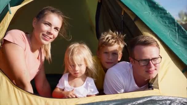 Junge Familie, die in einem Zelt sitzt und die Ferne zur Natur beobachtet, ist glücklich — Stockvideo