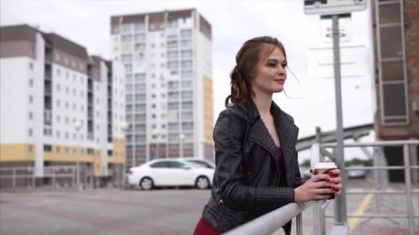 Souriante fille avec une tasse de café dans la rue — Video