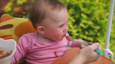 Küçük kız sebze püresi yemek, onu kaşıkla besliyor anne