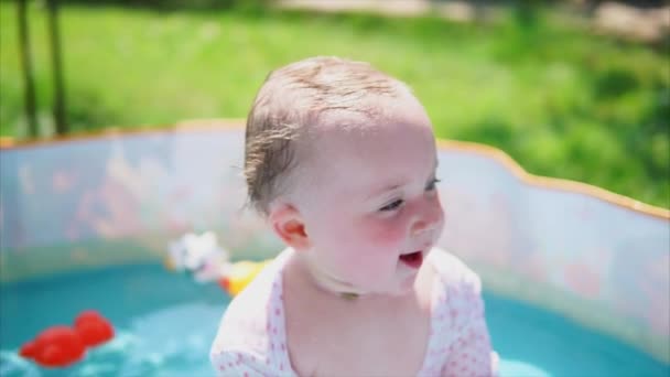 Happy baby girl having great summer day and bathing in outdoor pool — Stock Video