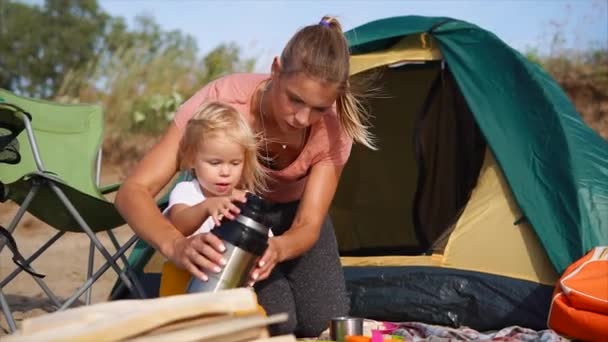 Mamá y su hija quieren calentarse con té caliente durante el viaje de campamento — Vídeo de stock