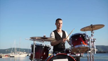 Profesyonel bir müzisyen bir davul ile plakalar ayarla denilen bir müzik aleti çalıyor